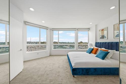 a bedroom with a bed and large windows at Penthouse Waterfront In the Heart of MDR/Venice/SM in Los Angeles