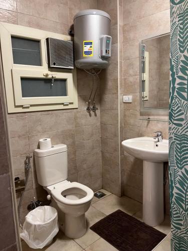 a small bathroom with a toilet and a sink at Chelay studios in Cairo