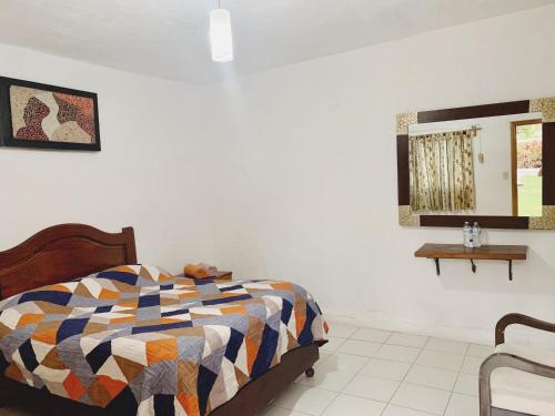 1 dormitorio con 1 cama con colcha colorida en Hotel Costa Belle en Monte Gordo
