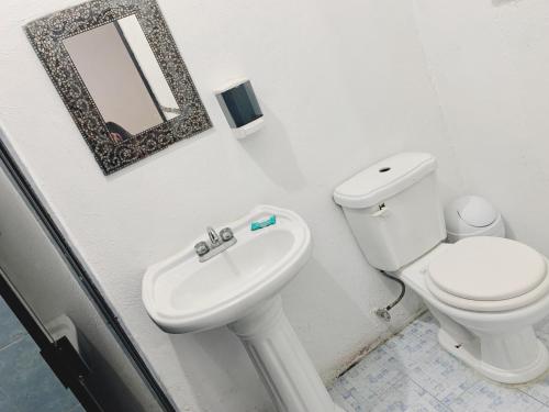 La salle de bains est pourvue de toilettes et d'un lavabo. dans l'établissement Hotel Costa Belle, à Monte Gordo