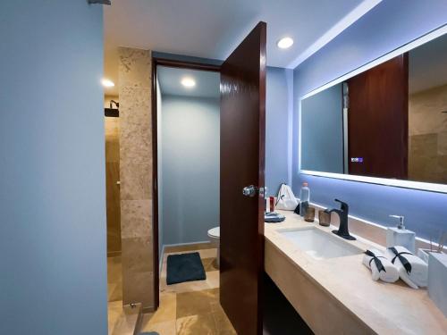 un baño con lavabo y espejo en Hotel Opus Grand Toluca Aeropuerto, en Toluca