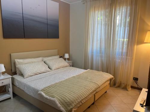 een slaapkamer met een bed en een groot raam bij Feli Holiday Home - Panoramic pool lake view in Gardone Riviera in Gardone Riviera