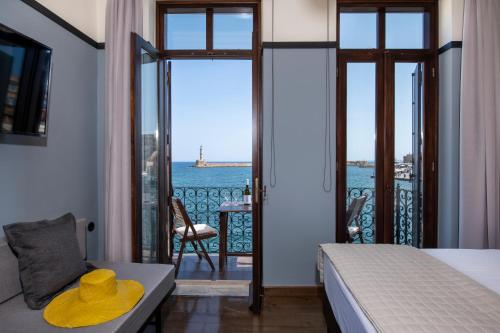 a bedroom with a bed and a view of the ocean at Mosaic Venetian Harbour Suites in Chania