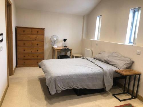 een slaapkamer met een bed, een bureau en een dressoir bij Flat in North Acton in Londen
