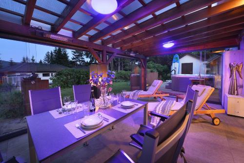 a patio with a table and chairs with purple lighting at Rekreační domek Kobylnice Lipno in Lipno nad Vltavou