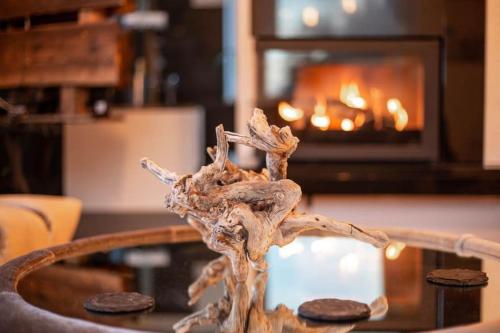 a tree branch in front of a coffee table with a fireplace at Altholz-Suite - Nationalpark Kalkalpen in Ramsau