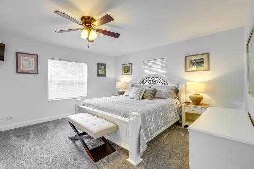 1 dormitorio blanco con 1 cama y ventilador de techo en Modern Ocala Oasis with Fire Pit and Gas Grill!, en Marion Oaks