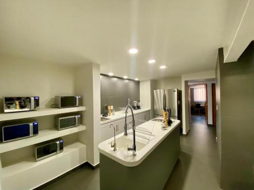 a large kitchen with a sink and a microwave at Bonsai Las Aguilas in Mexico City