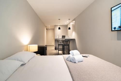 a bedroom with a bed with two towels on it at HMG Rio Suítes in Rio de Janeiro