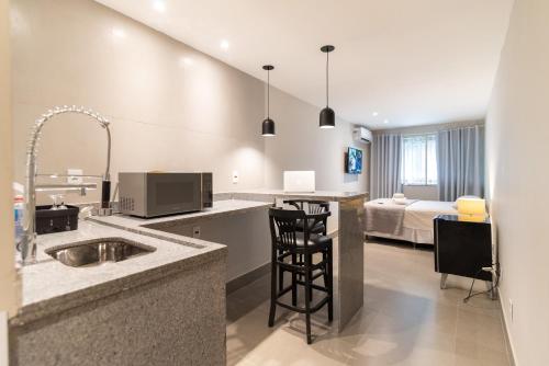 a kitchen with a sink and a kitchen with a bedroom at HMG Rio Suítes in Rio de Janeiro