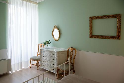 a room with a mirror and a dresser and a chair at Dimora del Castellano GREEN HOUSE in Gioia del Colle