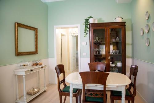 uma sala de jantar com uma mesa, cadeiras e um espelho em Dimora del Castellano GREEN HOUSE em Gioia del Colle