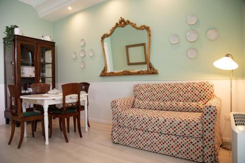 a living room with a chair and a table with a mirror at Dimora del Castellano GREEN HOUSE in Gioia del Colle