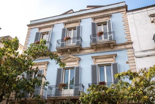 a blue building with windows and balconies at Dimora del Castellano GREEN HOUSE in Gioia del Colle