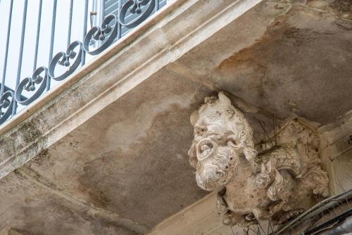 a stone face on the side of a building at Dimora del Castellano GREEN HOUSE in Gioia del Colle