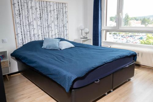 - une chambre avec un lit doté de draps bleus et une fenêtre dans l'établissement Blue Vibes, à Saint-Avold