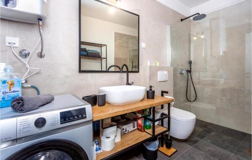 ein Badezimmer mit einer Waschmaschine und einem Waschbecken in der Unterkunft 2 Bedroom Stunning Apartment In Omisalj in Omišalj