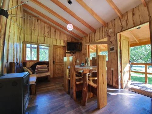 a wooden cabin with a table in a room at Karkú Lodge in Pucón