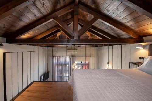 a bedroom with a large bed in a room with wooden ceilings at Mosaic Venetian Harbour Suites in Chania Town