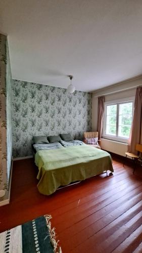 Un dormitorio con una cama grande y una ventana en Salonsaaren Pappila, en Terälahti