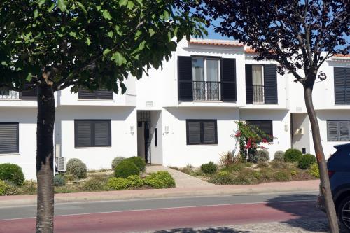una casa blanca con persianas negras en una calle en 2 bedroom apartment in Vale do Lobo, en Vale do Lobo