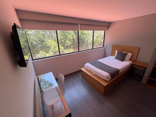 a small bedroom with a bed and a window at Bonsai Las Aguilas in Mexico City