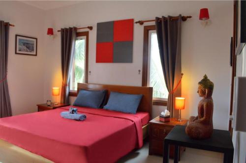 a bedroom with a red bed and two windows at Villa b.Maison d'Hôtes Angkor in Siem Reap