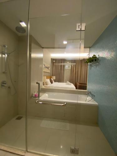 La salle de bains est pourvue d'une douche en verre et d'un lit. dans l'établissement KLCC by SWITZHOME, à Kuala Lumpur