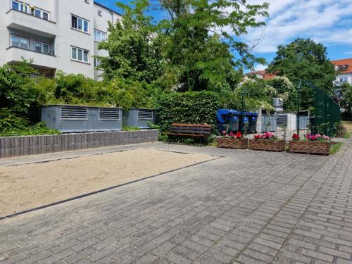 un patio con un banco y flores en HappySide - iNDUSTRiAL DESiGN - KÜCHE - CiTY NAH -, en Leipzig