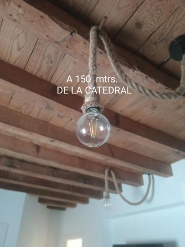 una luce appesa a un soffitto in legno in una stanza di SEÑORÍO DE ORGAZ III a Toledo