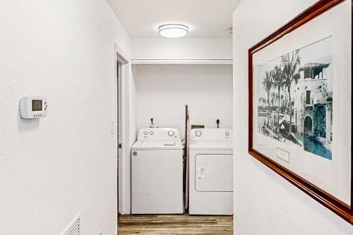 a hallway with two washing machines and a picture at Dolphin Court #9 in St Pete Beach