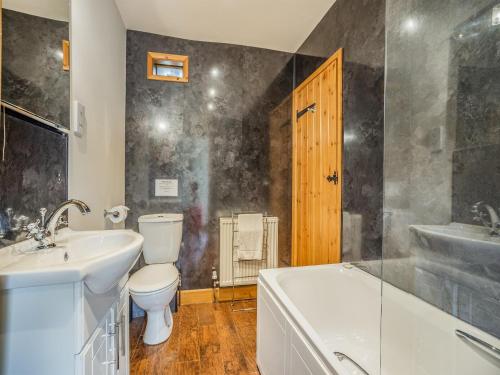 a bathroom with a sink and a toilet and a tub at The Forge - Uk44517 in North Thoresby