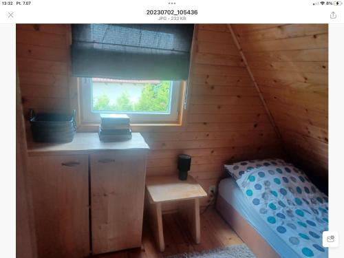 a small room with a bed and a window at Kajetanówka in Jackowo