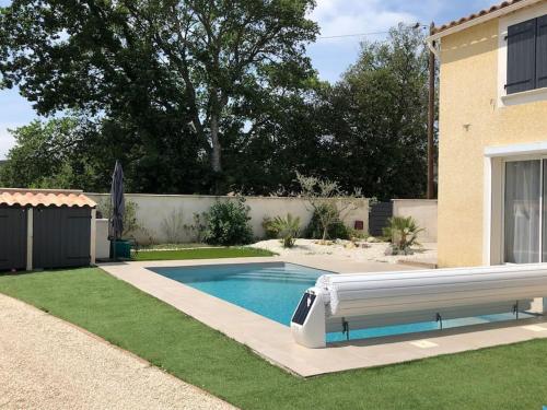 une piscine dans une cour à côté d'une maison dans l'établissement Villa Firenze, à Montségur-sur-Lauzon