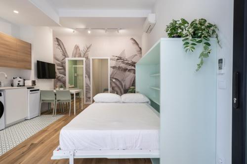 Cet appartement comprend une chambre avec un lit blanc et une cuisine. dans l'établissement Marina Beach Apartments, à Valence