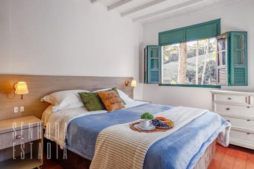 Un dormitorio con una cama y una mesa con un plato. en Alpen Ville Sítio com Piscina Inesquecível, en São Pedro de Alcântara