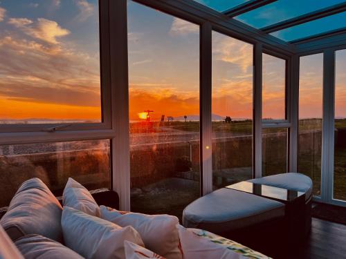 a living room with a couch and a view of the ocean at Sunset House On The Beach in Maryport