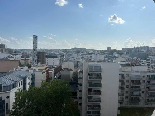 a city with buildings and mountains in the background at Superbe T2 type loft proche Paris La Défense Arena et 30 min stade de France in Puteaux
