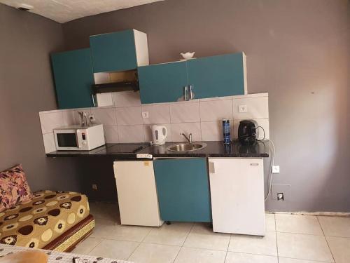 a kitchen with blue and white cabinets and a sink at studio tranquille in Pavillons-sous-Bois