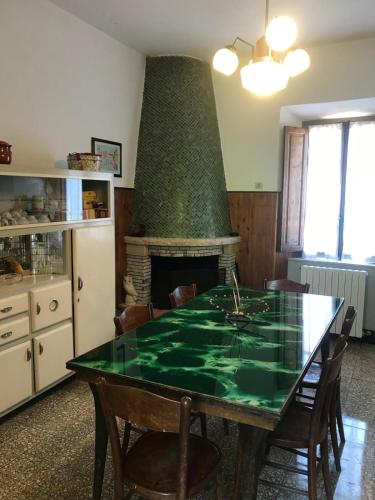a dining room with a green table and a fireplace at Villa Margherita in Grotte