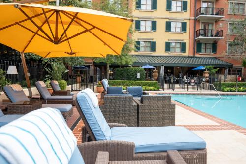 a pool with chairs and umbrellas next to a building at Hotel Granduca Houston in Houston