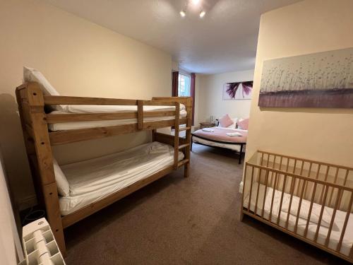 a room with two bunk beds and a crib at The George Centre in Matlock