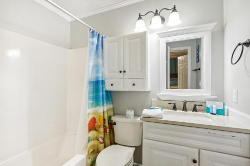 y baño con aseo, lavabo y espejo. en Hilton Head Vacation Rental Private Beach Access! en Hilton Head Island