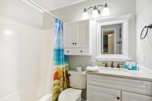 a bathroom with a toilet and a sink and a mirror at Hilton Head Vacation Rental Private Beach Access! in Hilton Head Island