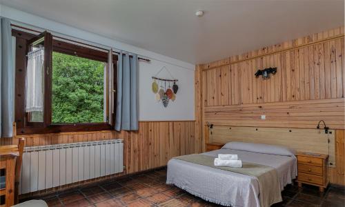 um quarto com uma cama e uma janela em Agroturismo Kostegi em Urnieta