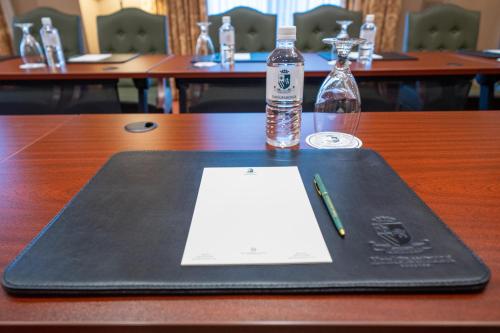 a book and a bottle of water and a pen on a table at Hotel Granduca Houston in Houston