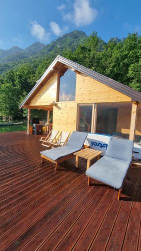 eine Terrasse mit 2 Liegestühlen und ein Haus in der Unterkunft Lake house Perucac in Bajina Bašta