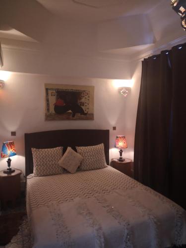 ein Schlafzimmer mit einem Bett mit zwei Lampen an Tischen in der Unterkunft Riad El Badii in Marrakesch
