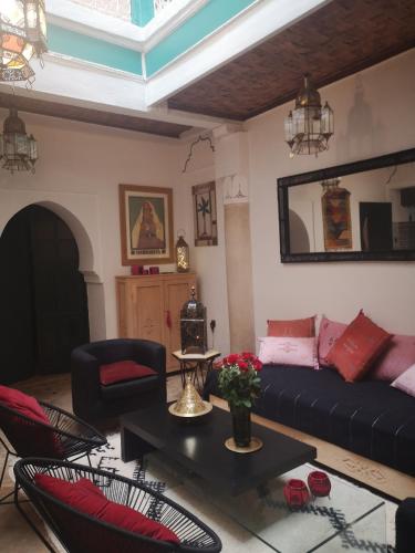 ein Wohnzimmer mit einem Sofa und einem Tisch in der Unterkunft Riad El Badii in Marrakesch