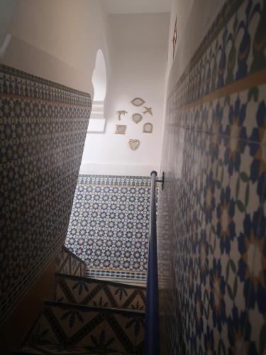 a stairway with blue and white tiles on a wall at Riad El Badii in Marrakesh